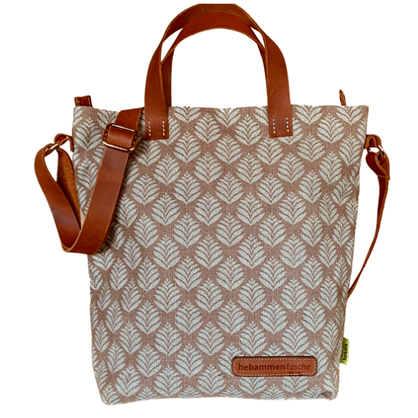 Hebammentasche "Bonnie" in Rosé. Die kurzen und langen Henkel bestehen aus einem braunen Leder, sowie der vordere Aufdruck "hebammentasche". Die Tasche ist mit einem Blätter-Print verziert.