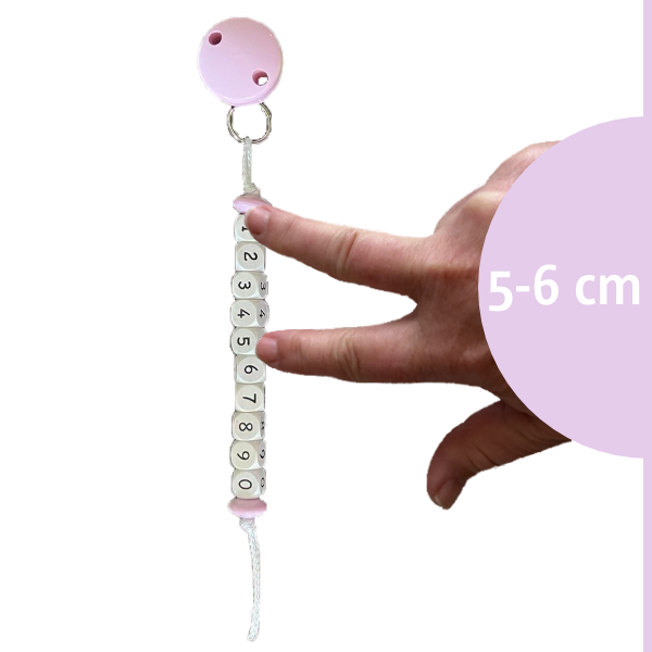Muttermundperlen in lila mit einer Hand, die eine Muttermundweite von 5 bis 6 Zentimetern veranschaulicht.